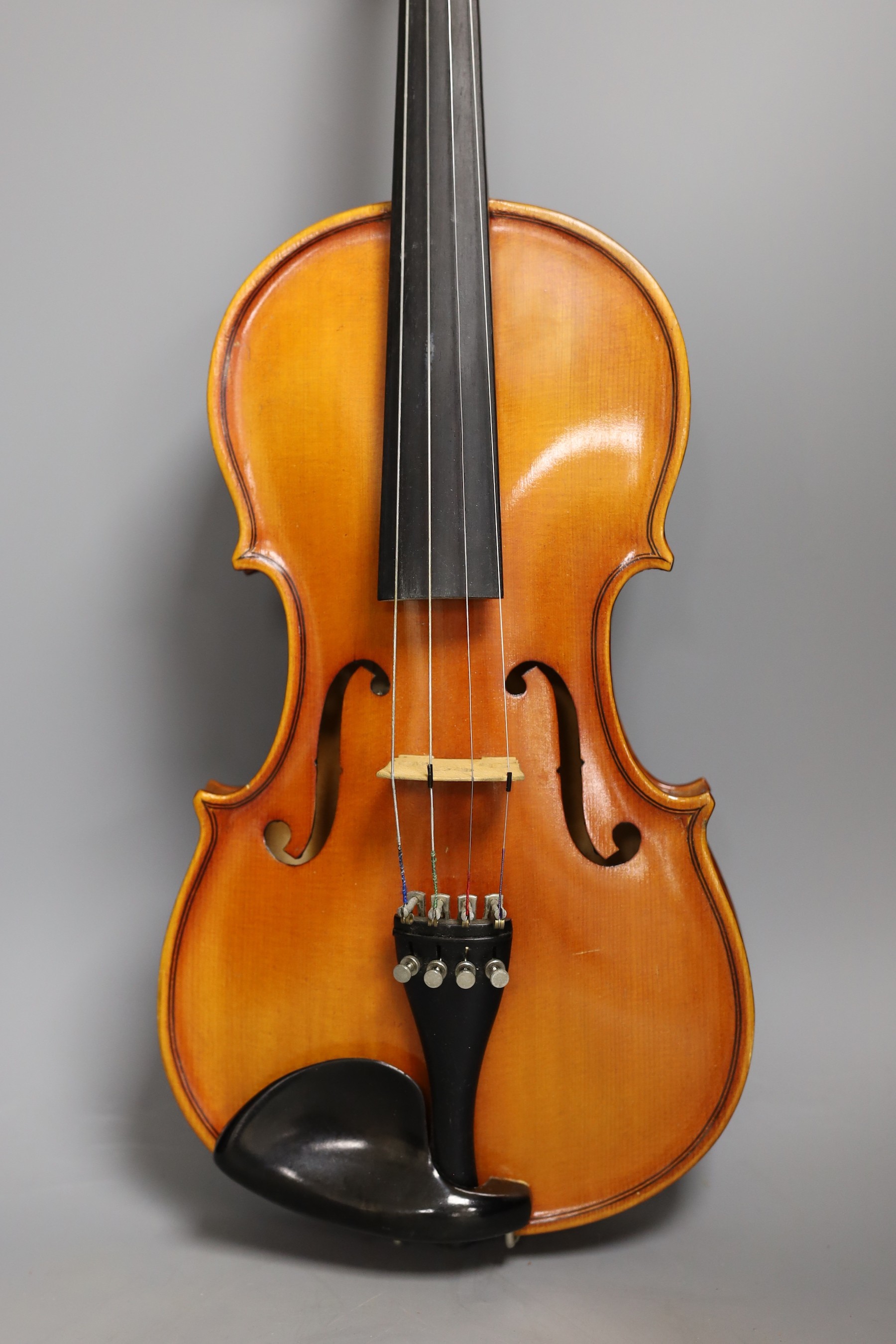 A cased child's violin and bow with ivorine tip, violin 55cms long